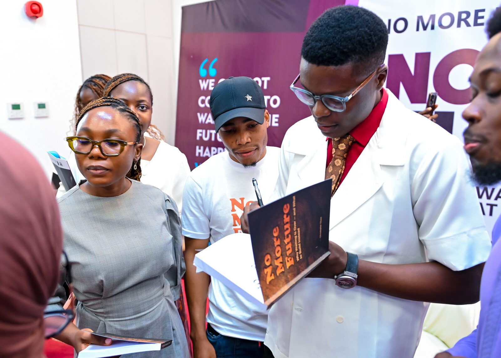 Christopher Olusa signing a copy of No More Future for a guest